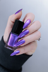 Woman hand with long nails and a bridht purple nail polish
