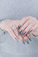 Female hand with long nails and a gray silver manicure