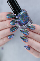 Female hand with long nails and a gray silver manicure