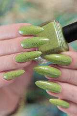 Female hand with long nails and neon yellow green manicure