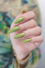 Female hand with long nails and neon yellow green manicure