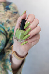Female hand with long nails and neon yellow green manicure