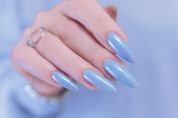 Woman's beautiful hand with long nails and light baby blue manicure