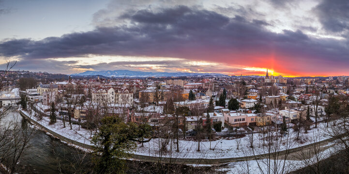 A winter panorama of the town of Česk&yacute; Tě&scaron;&iacute;n and the Beskid Mountains, visible from Cieszyn Castle Hill. A beautiful sunset. The Olza River in the foreground. The border of the two countries. Poland