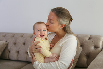 Mom kissing her happy baby. Copy space, background.