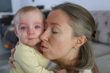 Mother soothing her crying baby. Background.
