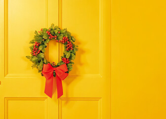 a wreath on a yellow door with a red bow