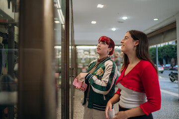 Young women window shopping on city street