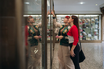 Friends window shopping at mall looking at shoes