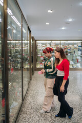 Young women window shopping for shoes together