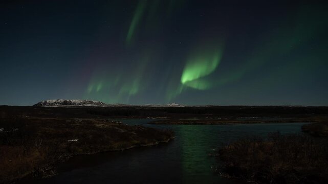 Full sky long duration realistic aurora borealis over scenic Thingvellir lake Iceland