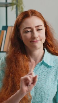 Displeased upset young redhead woman reacting to unpleasant awful idea, dissatisfied with bad quality, wave hand, shake head No, dismiss idea, dont like proposal at home. Lady sitting on sofa at home
