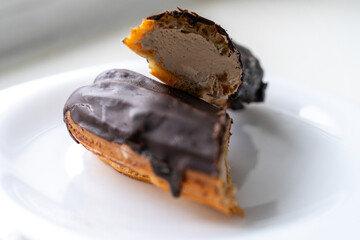 Elegant eclair filled with vanilla buttercream and dipped in chocolate.