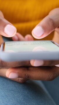Close up of a Black woman's hands typing a message on a smartphone screen. vertical video