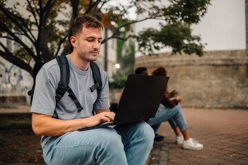 College student using laptop outdoors on campus