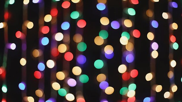 Abstract festive background loop featuring colorful twinkling string lights and soft out-of-focus bokeh circles shimmering against a dark setting christmas, overlay, wallpaper
