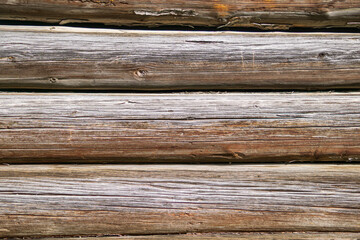 Weathered wooden logs forming rustic wall texture