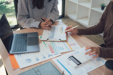 Strategic Collaboration: Two businesswomen engage in a dynamic dialogue at a meeting, collaborating and dissecting financial data