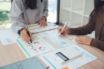 Collaboration in Analysis: Two professionals collaboratively analyze financial data, the scene bathed in natural light, signifying teamwork, decision making and strategic planning. 