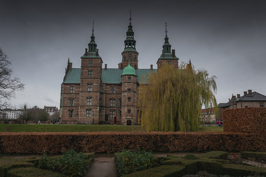 Rosenborg Castle garden view with spires and willow in Copenhagen