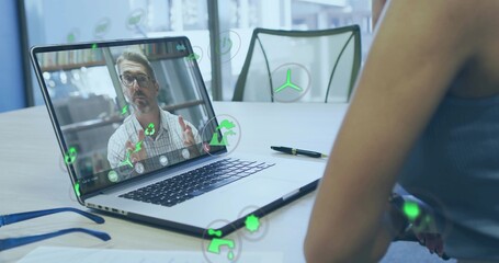 Showing laptop-screen presenter gesturing at table, woman in sleeveless top, pen, glasses, AR icons