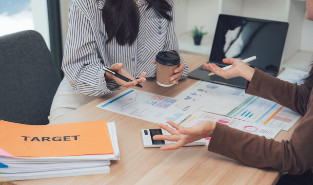 Workplace Dialogue: Capturing a candid moment during a collaborative business discussion, two professionals, deep in thought, exchange insights around a workspace. - Powered by Adobe