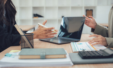 Business discussion: A detailed shot of two individuals engaged in a dynamic business discussion within a modern office setting. Captured at eye-level to depict clarity and collaboration.