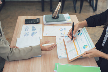 Business Meeting: A close-up view capturing the dynamic of a business meeting, where two professionals collaborate over a collection of documents and data.