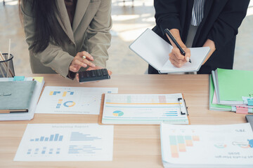 Business Collaboration: Two professionals engage in a focused discussion, analyzing data and strategizing for success, highlighting the dynamic interaction of workplace collaboration.