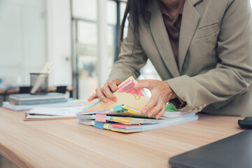 Organized Work: A focused individual sorts through a pile of documents on a desk, a scene representing focused work, diligent effort, and organization
