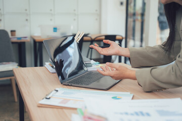 Laptop screen at Workplace: An individual at a desk is utilizing a laptop. Surrounded by office elements. A scene capturing office routine.