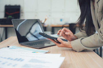 Businesswoman doing Calculation: Focused business lady at her desk, engrossed in analyzing financial data, leveraging calculator and computer.