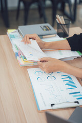 Desk analysis: An insightful image showcases a close-up of hands meticulously organizing documents, embodying the essence of analysis.