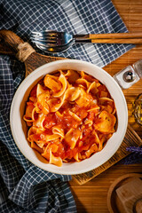 Pieces of chicken with noodle in tomato and herb sauce.