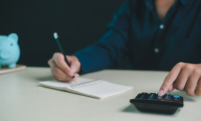 Person calculating budget with calculator and notebook on desk, financial planning and saving money concept, personal finance management, expense tracking, smart budgeting for home.