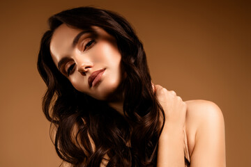 Portrait of a Young Woman with Beautiful Makeup and Elegant Hairstyle on a Beige Background