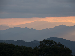 Obraz premium Cloudy sunset palette of shades of brown, orange and gold viewed from the Craggy Gardens Outlook outside Asheville North Carolina towards the Great Smokey Mountains of Tennessee