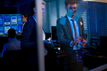 Professional corporate executives planning strategic business goals on whiteboard. Leadership team analyzing financial market trends and project workflow in modern office at night.