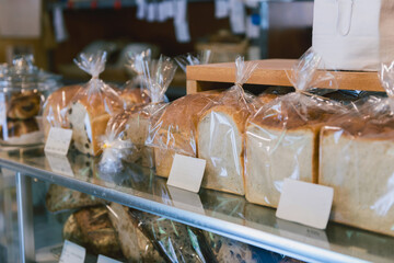 包装された食パンが並ぶベーカリーの店内風景