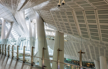 Naklejka premium Hong Kong West Kowloon Station, Hong Kong, China, 1 March 2025: abstract interior view of the high speed rail terminal highlighting curved roof structure and architectural design