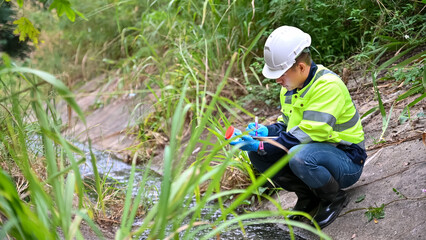 Environmental Inspector Collecting Water Sample from Stream for Quality Testing and Safety Monitoring © SAHARAT