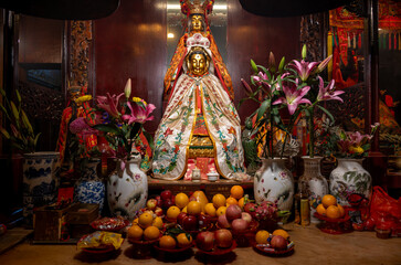 Man Mo Temple, Hong Kong, China : altar with Taoist deity statue, offerings of fruit and flowers inside the historic temple near Hollywood Road