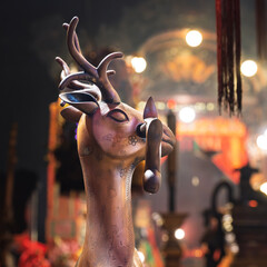 Man Mo Temple, Hong Kong, China, 5 March 2025: bronze deer statue inside the Taoist temple, symbol of wisdom and learning, illuminated by ritual lights and incense glow
