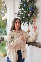 Woman wearing traditional Ukrainian embroidered shirt with handmade straw Christmas ornaments. 