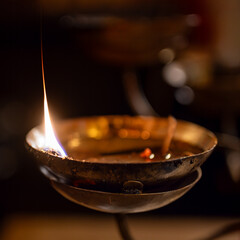 Man Mo Temple, Hong Kong : close-up of a ritual oil lamp flame burning during a traditional Taoist prayer ceremony