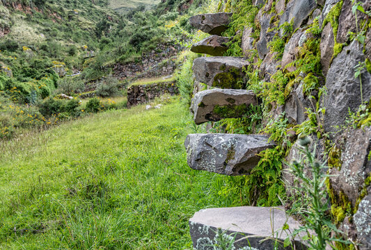 Ancient Inca stone steps built into an agricultural terrace wall in the Pisac Archaeological Park, Peru.