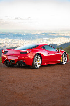 Red Ferrari 458 Italia rear three quarters view, Luxury sports coupe on hill