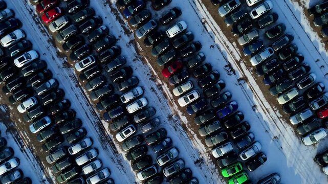 Aerial view of symmetrical rows of cars and vehicles in car storage facility. Cars moved for import and export for customers, snowy conditions in winter in Corby, United Kingdom.