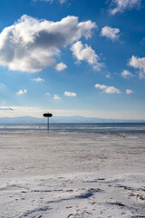frozen bay of Lake Constance in Wasserburg Germany with blue sky and clouds