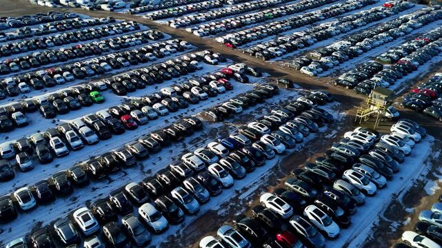 Aerial view of symmetrical rows of cars and vehicles in car storage facility. Cars moved for import and export for customers, snowy conditions in winter in Corby, United Kingdom.